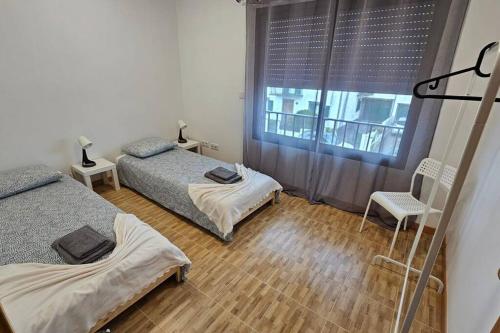 蓬塔德尔加达Casa da Relva的一间卧室设有两张床和窗户。