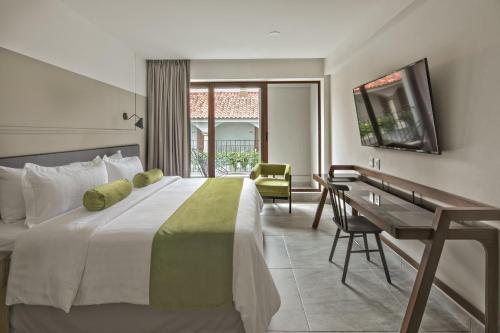奥里萨巴Gamma Orizaba Grand Hotel de France的酒店客房设有一张大床和一张书桌。