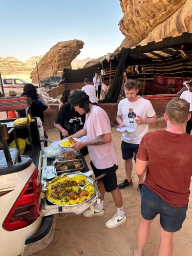 瓦迪拉姆Panorama camp jeep trips的一群人站在食物自助餐周围