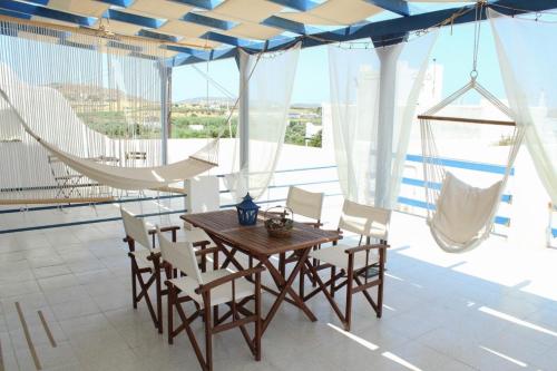 洛加拉斯Klironomos Apartments Logaras的一间带木桌和椅子的用餐室