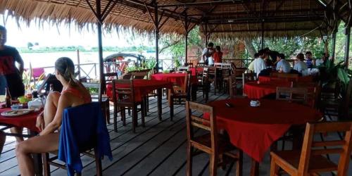 永隆幸福家庭旅馆的坐在餐厅里,有红色桌子和椅子的女人