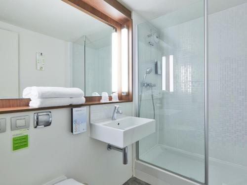 桑利斯钟楼赛利酒店的白色的浴室设有水槽和淋浴。