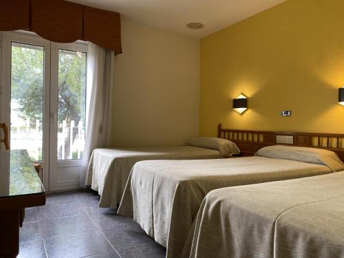杰里亚La Colina的酒店客房设有三张床和窗户。
