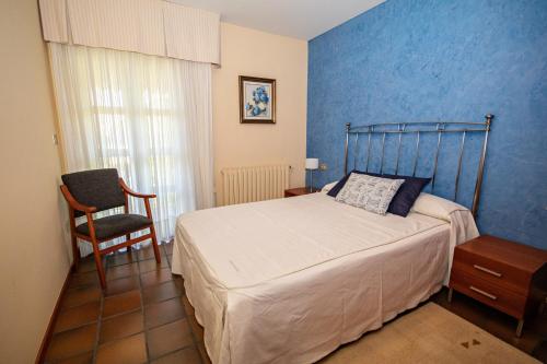 阿尔丹2 bedrooms appartement at Vilanova 100 m away from the beach with sea view enclosed garden and wifi的一间卧室配有一张床和一把椅子