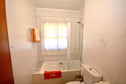 阿尔丹2 bedrooms appartement at Vilanova 100 m away from the beach with sea view enclosed garden and wifi的带淋浴、卫生间和浴缸的浴室