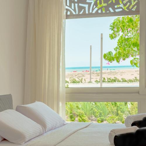 赫尔格达Mangroovy Seaview 3BR Beach and Pool Free access的一间卧室设有窗户,享有海滩美景
