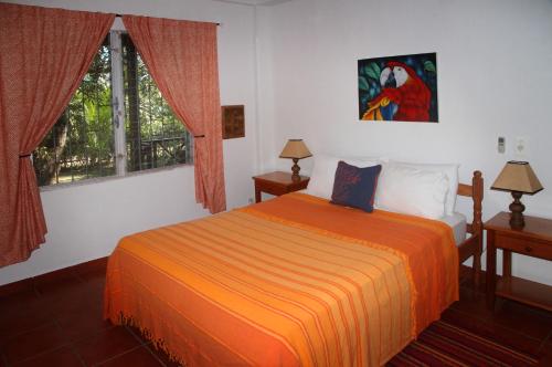 蓬塔戈尔达BlueBelize B&B的一间卧室配有一张带橙色毯子的床