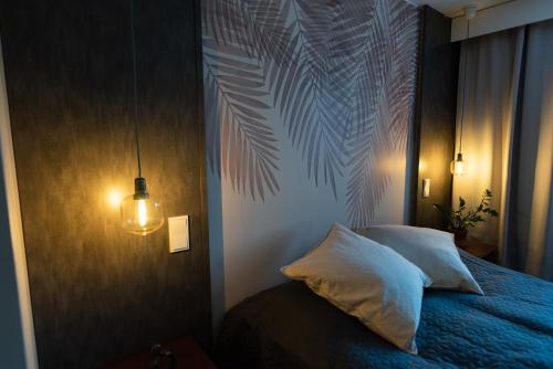 坦佩雷Tyylikäs City-huoneisto的一间卧室配有一张蓝色的床,拥有棕榈叶壁画