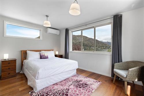 皇后镇Lake and Mountain view living的一间卧室设有一张床和一个大窗户
