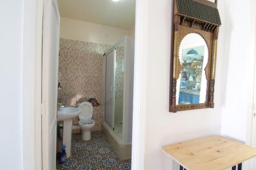 沃利迪耶zina surf house的浴室设有卫生间和墙上的镜子。