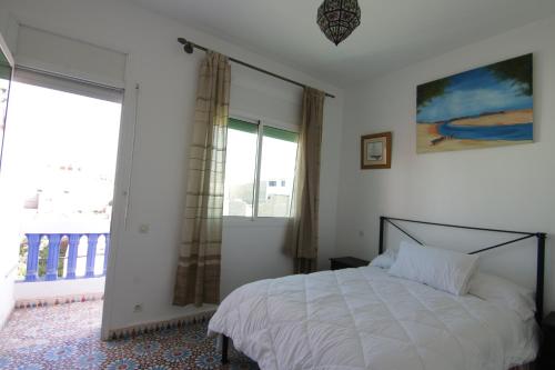 沃利迪耶zina surf house的一间卧室设有一张床和一个大窗户