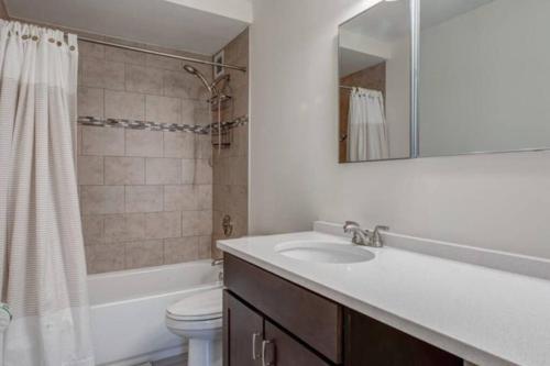 波士顿BackBay Center Lux 2BR 2BA condo的一间带水槽、卫生间和镜子的浴室