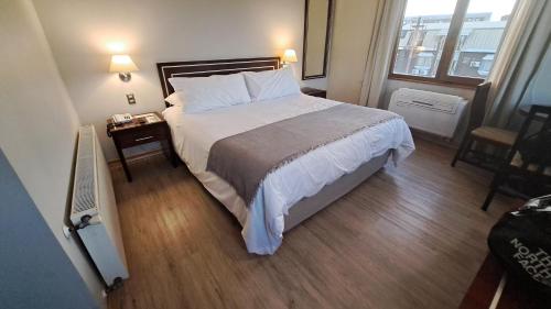 瓦尔迪维亚迭戈阿尔马格罗瓦尔迪维亚酒店的一间卧室设有一张大床,铺有木地板