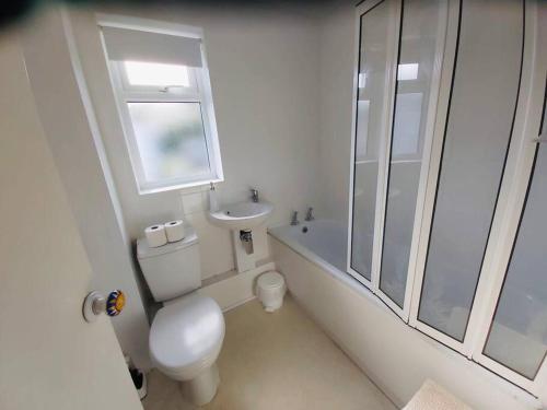 利斯卡德Light and bright 3 bedroom bungalow in Cornwall的白色的浴室设有卫生间和水槽。