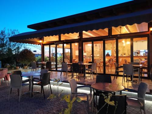 都拉斯Te Aldo Hotel的餐厅设有桌椅和窗户。