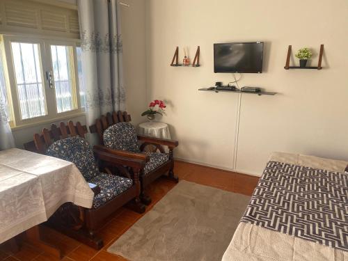 卡波布里奥Pousada Apartamento loft Braga的用餐室配有椅子和墙上的电视
