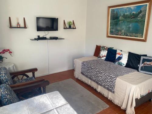 卡波布里奥Pousada Apartamento loft Braga的客房设有两张床和一台墙上的电视。