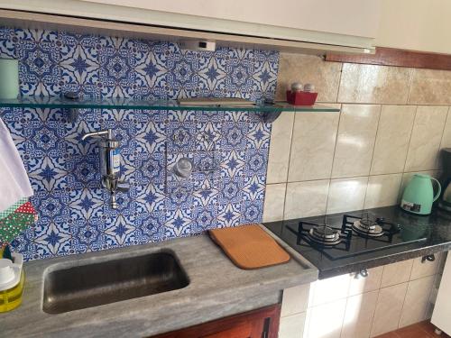 卡波布里奥Pousada Apartamento loft Braga的厨房配有水槽以及蓝色和白色的瓷砖