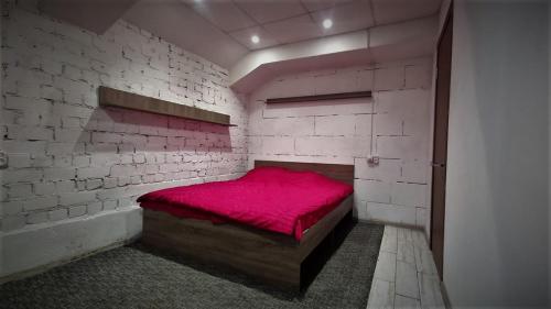 基辅Міні Готель "БУНКЕР" на Солом'янському的一间砖墙内红色床的卧室