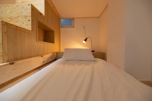 庆州Aha Stay的一张大白床,位于带灯的房间