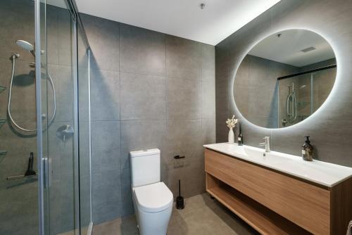 芒格努伊山Executive Oceanside Apartment的一间带卫生间、水槽和镜子的浴室