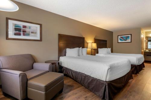 萨蒙阿姆SureStay Plus Hotel by Best Western Salmon Arm的酒店客房,配有两张床和椅子
