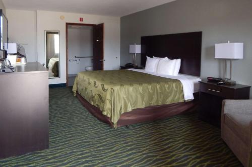 Siloam SpringsQuality Inn Siloam Springs West的酒店客房设有一张大床和一张沙发。