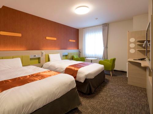 宫崎Comfort Hotel Miyazaki的酒店客房设有两张床和电视。
