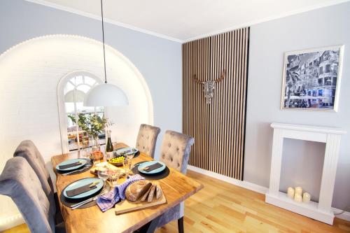不莱梅Mediterrane Wohnung nahe HBF mit Domblick的一间带木桌和椅子的用餐室