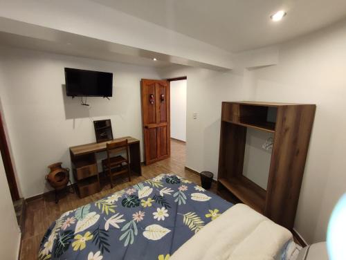 库斯科linda house cusco的卧室配有一张床,墙上配有电视。
