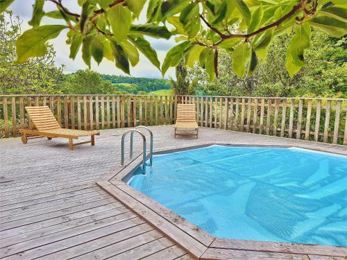莫尔莱Villa Saint Kirio - piscine et spa的甲板上的游泳池,配有两把椅子和长凳
