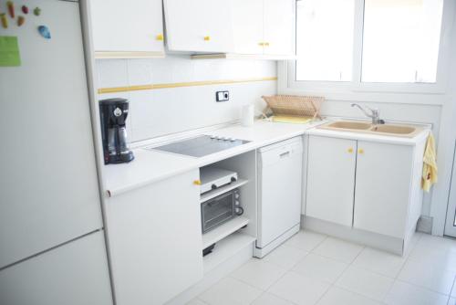 莫莱拉Appartment Kristal Mar II的白色的厨房配有白色橱柜和水槽