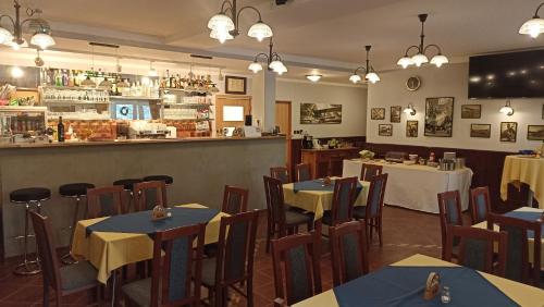 姆拉代布基Penzion U Halířů的一间带桌椅的餐厅和一间酒吧