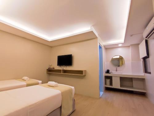 卡利博Hotel Simone Kalibo的一间酒店客房,设有两张床和电视