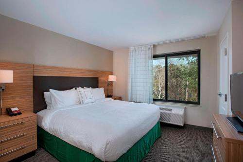 斯莱德尔TownePlace Suites by Marriott Slidell的一间设有大床和窗户的酒店客房