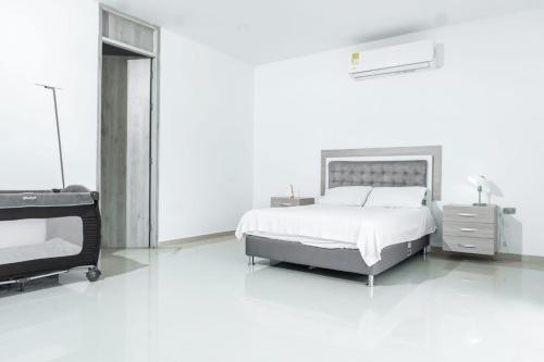 圣玛尔塔Casa finca con piscina的一间白色卧室,配有床和电视