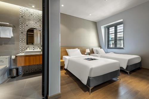 富国Laputa Hotel Phu Quoc的酒店客房设有两张床和盥洗盆