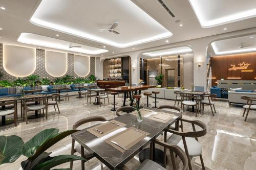富国Laputa Hotel Phu Quoc的一间带桌椅的餐厅和一间酒吧
