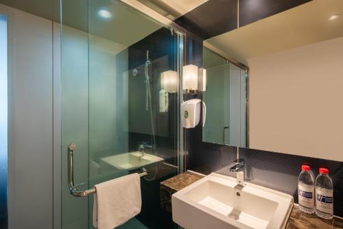 抚松县长白山万达智选假日酒店的一间带水槽和玻璃淋浴的浴室