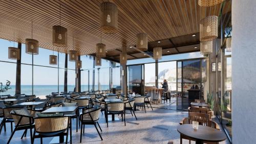 河静Seabird Hotel Thien Cam的一间带桌椅的海景餐厅