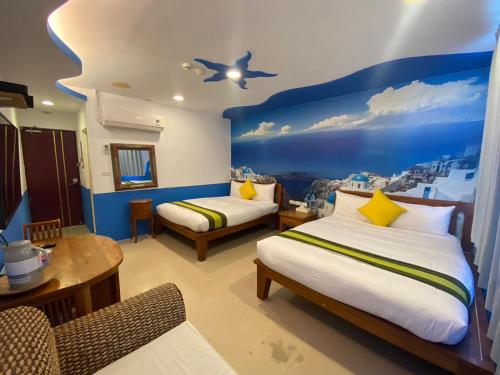 垦丁大街垦丁欣欣渡假旅馆的一间卧室设有两张床和蓝色的墙壁