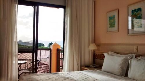 弗洛里亚诺波利斯Jurerê Beach Village Studios Para Temporada的酒店客房设有一张床和一个阳台。