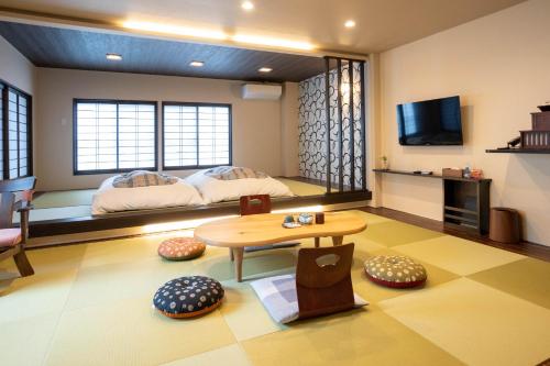 高山英太郎日式旅馆的客厅配有床和桌子
