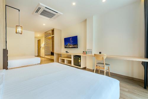 曼谷Phra Nakhon Poshtel的白色卧室配有床和书桌