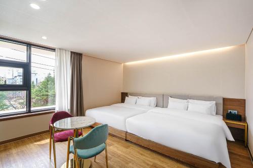 全州市Browndot Hotel Jeonju Ajung的酒店客房设有一张大床和一张桌子。