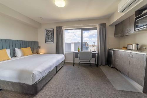 洛坎普顿罗克汉普顿之客公寓式酒店的酒店客房设有一张大床和一个厨房。