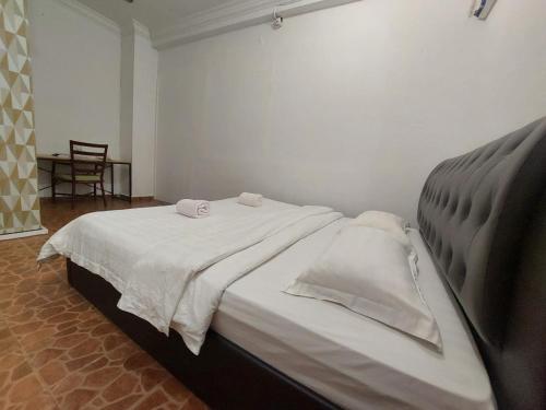 仙本那Warisan Family inn @ Seafront的一间卧室配有一张床,上面有两条毛巾