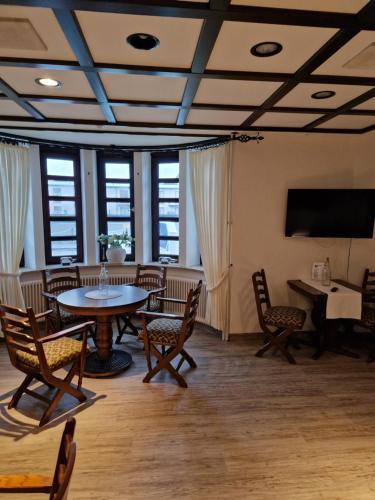 库克斯港米雷斯弗莱德酒店的配有桌椅和电视的客房