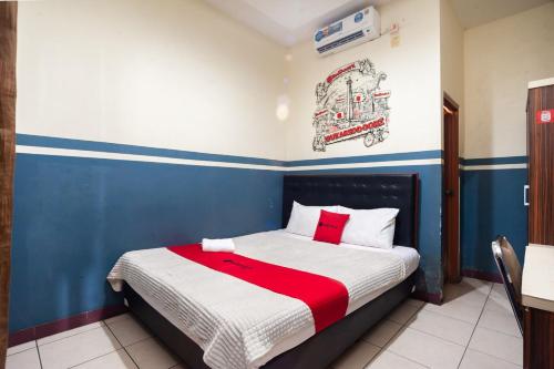雅加达RedDoorz Plus near Universitas Indonesia的一间卧室配有一张带红白毯子的床