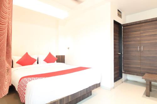 DehuNew Pune Residency的一间卧室配有红色枕头的床